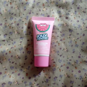Jolly Rancher Watermelon Scented Hand Cream - En söt och fruktig handkräm med doft av vattenmelon från Normal. Den kommer i en rosa tub med ett lekfullt designat lock. Perfekt för att hålla händerna mjuka och väldoftande. Använd några gånger
