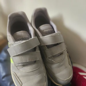 Grå sneakers från Adidas - Säljer ett par grå sneakers från Adidas med  grepp och är perfekta för aktiva dagar. Tillverkade i syntetmaterial för hållbarhet och komfort.