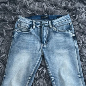 Blå jeans från Kenneth Cole - Feta blå slim jeans från Kenneth Cole med en klassisk femficksdesign. De har en lätt tvättad look och normal passform. Perfekta för en avslappnad stil.