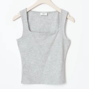 Grå linne Gina - Snygg och enkel grå linnetopp med breda axelband. Perfekt för en avslappnad stil eller som basplagg i garderoben. Från Gina, använd bara någon gång.