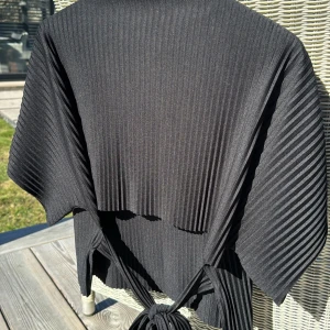 Svart ribbad topp från Gina Tricot - Snygg svart ribbad topp från Gina med korta ärmar och knytning i midjan.🤩 Supersnygg både att klä upp och ha till vardags🥰🌸 Toppen är i jätte bra skick i storlek XS