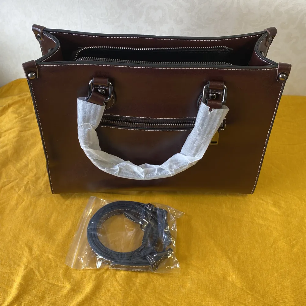 Helt ny .( Äkta läder ) . Handväska Kvinnor Cross body Axella Äkta Läder Shopping Mode Kontor Kvinnlig Riktigt Kohud Messenger Top Handtag Väskor Snygg brun skinnväska med praktiska handtag och en avtagbar axelrem. Väskan har flera fack med dragkedja för enkel organisering. Perfekt för att bära dina dagliga nödvändigheter med stil.. Laukut & Käsilaukut.