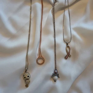 Fyra halsband med olika hängen - Säljer fyra unika halsband med olika hängen: en uggla med glittriga stenar, en cirkel med små stenar, ett bandformat hänge med rosa stenar och en ängel med pärla och glittrig kula. Perfekta accessoarer för att ge din outfit en personlig touch. De kostar 25 kr st 🫶