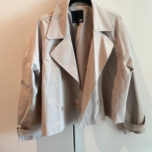 Beige kort trenchcoat  - Kort beige trenchcoat i jätte bra skick!