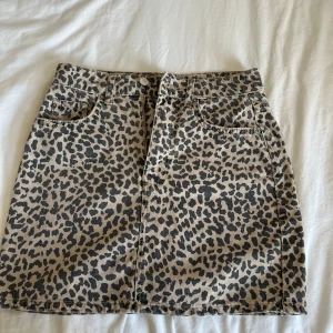 Leopardmönstrad kort jeanskjol  - Snygg leopardmönstrad kortkjol från Gina Tricot. Kjolen har en klassisk femficksdesign och är tillverkad i ett slitstarkt material. Perfekt för att ge din outfit en trendig touch. 🐆🩷