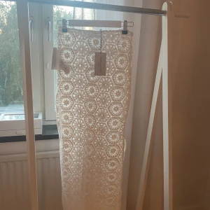 Helt Ny Vit Virkad Kjol NA-KD Storlek 34 - Superfin långkjol i virkad stil från Belen Hostalet x NA-KD. Kjolen är vit med ett unikt blommigt mönster och har en rak passform 🤍Oanvänd med lappar kvar.