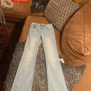 Ljusblå bootcut jeans från Kappahl  - Snygga ljusblå jeans från Kappahl i storlek 158. Modellen har bootcut-ben och klassisk femficksdesign. Jeansen är tillverkade i mjukt denimtyg och har en fräsch, ljus tvätt som ger en cool och avslappnad vibe.
