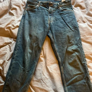 Weekday Barrel jeans blå 30/32 - Säljer ett par Weekday Barrel jeans i en blå och grön tvätt. Modellen är relaxed tapered med normal passform och avsmalnande ben. Jeansen har fem fickor, bälteshällor och är gjorda i bomull. Perfekta för en chill och stilren look.