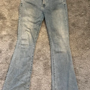 Ljusblå bootcut jeans True Religion - Säljer ett par ljusblå jeans från True Religion med klassiska broderade bakfickor och silverfärgade knappar. Jeansen har bootcut-modell och är tillverkade i mjukt denimtyg. Perfekta för dig som gillar en avslappnad men ändå snygg look. Bara använda två gånger!