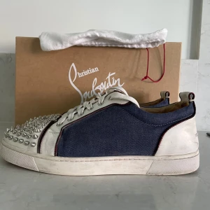 Christian Louboutin sneakers med nitar - Säljer dessa tvär snygga sneakers från Christian Louboutin i blått tyg med vita skinnpartier och röda signatursulor. Skorna är i skick 8/10🤩 storleken är 42.5 men passar 43 och är självklart äkta🤩Hör av er vid minsta lilla fråga😊
