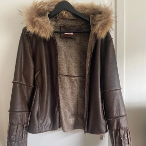 Brun pälsfodrad jacka från LIKO&CO - Snygg brun jacka från LIKO&CO med fuskpäls. Köpt på Vinted för 999kr men aldrig använt då den inte satt så bra på mig! 