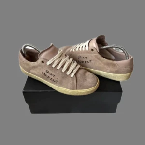 Beige mocka sneakers från Saint Laurent - Snygga beige sneakers i mocka från Saint Laurent med vit snörning🔥 nypris runt 7-8 tusen vårt pris 3,249 otroligt bra skick✨ Passar stolek 42-43 hör av vid frågor kring pris och mer bilder!! OPS Får med og och box( ett kuvert med äkhetsbrvis!