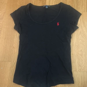 Ralph Lauren topp - Svart t-shirt från Ralph Lauren med klassisk rund halsringning och korta ärmar. . Perfekt för en clean och stilren look. Använd ganska många gånger men är i fint skick och inget tecken på ancändning!