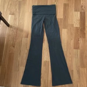 Svarta bootcut yogabyxor - Säljer ett par gröna yogabyxor med  bootcut-ben. Byxorna är gjorda i mjukt och stretchigt material, perfekta för chill dagar eller yoga. De har en bred linning som kan vikas ner för extra komfort.
