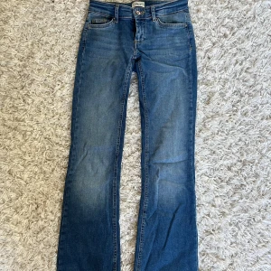 Blå lågmidjade bootcut jeans från ONLY  - Snygga blå bootcut jeans från ONLY i storlek XS och längd 34. Klassisk femficksmodell med låg midja och lätt utsvängda ben. Jeansen är gjorda i mjukt denimtyg med lite stretch för extra komfort. Skriv för fler bilder eller mått!💕