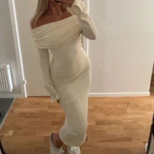 Offshoulder långklänning  - Supersnygg långklänning i ljus beige med offshoulder och långa ärmar. Klänningen har en tight passform som framhäver figuren. Dessutom är den oanvänd och köpt på GinaTricot!