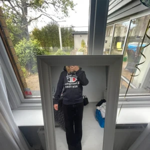 Svart hoodie från Champion med tryck - Svart hoodie från Champion, lite slitet på ena snöret(bild 3) men annars bra sick. Storlek S 