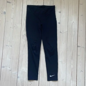 Svarta Nike Dri-Fit träningsbyxor - Sitter tajt och har en normal hög midja.