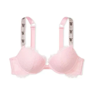 Rosa spets-bh från Victoria's Secret - Supersöt rosa bh med spetsdetaljer och vadderade kupor från Victoria's Secret. Axelbanden är dekorerade med VS-logga och glittrande stenar för extra bling. Perfekt för dig som vill ha något både gulligt och trendigt under kläderna.
