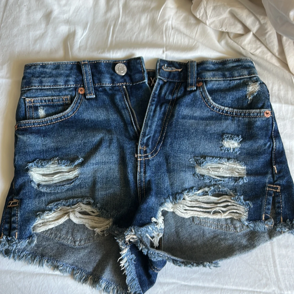 Blå slitna jeansshorts