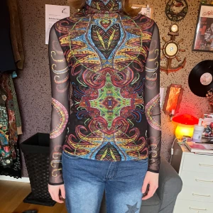 Desigual meshtopp - Ascool mesh polotröja med psykadeliskt mönster från desigual! Går lika bra att ha på sig bakåtfram om man skulle föredra det <3 Har använt väldigt få gånger. Lappen med storlek på är avklippt men jag skulle säga att den är en XS/S