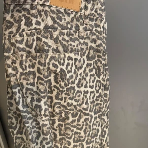 Leopardmönstrade jeans från STR Teen - Snygga jeans från STR Teen i beige och grått leopardmönster. Jeansen är raka i modellen. Köpta utomlands och använda 1/2 gånger.