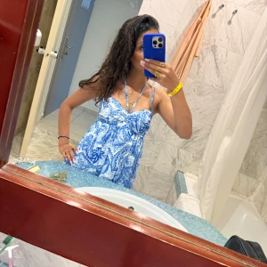 Blåvit  sommarklänning med mönster - Supersöt blåvit klänning med paisley-inspirerat mönster och smala axelband. Klänningen har omlottkänsla upptill och knyt runt nacken för extra detalj. Perfekt för varma dagar och ger en fräsch vibe. Helt ny 