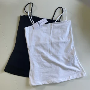 Linnen från Gina tricot - Säljer ett 2-pack linnen från Gina tricot i storlek s. Modell: 2-pack scarlet long singlet  black/white. Oanvända med lappen kvar. Säljer samma modell fast ”black” och även ”pack scarlet singlet” fast i andra annonser. Köparen betalar frakten!