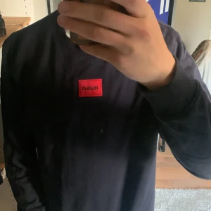 Mörkblå sweatshirt från Hugo - Pris kan diskuteras Säljer en stilren mörkblå sweatshirt från Hugo med klassisk rund hals och ett rött Hugo-logomärke på bröstet. Tröjan har långa ärmar och ribbade muddar vid ärmslut och nederkant. Perfekt för dig som gillar enkel men snygg design.