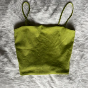 Grön ribbad linnetopp från Monki - Säljer en ribbad linnetopp från Monki i storlek M. Toppen är något croppad och har smala axelband.