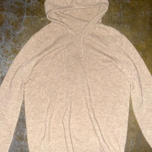 Beige hoodie i merinoull  - PRIS KAN DISKUTERAS! Mysig beige hoodie med huva och dragsko, tillverkad i mjuk merinoull . Tröjan har lång ärm och en enkel, stilren design utan tryck eller mönster. Perfekt för dig som gillar en clean och chill look.