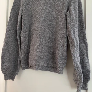 Grå stickad tröja från Object - Mysig grå stickad tröja från Object i storlek S. Tröjan har en enkel och avslappnad passform med långa ärmar och ribbade muddar. Perfekt för lager-på-lager och chill dagar. Snygg att matcha med jeans eller kjol.