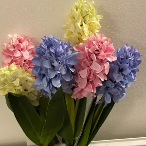 Hyacint - En färgglad och naturtrogen konstväxt som livar upp ditt rum! Hyacinten finns i blått, rosa och gult och passar perfekt för dig som vill ha blomsterkänsla utan underhåll. Perfekt för att skapa en mysig och trendig inredning.