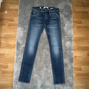 Replay Anbass  blå - Snygga blå Replay Anbass jeans i slim fit med klassisk femficksdesign och coola slitningar. 