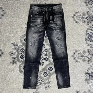 Dsquared2 jeans - Riktigt snygga svarta jeans från Dsquared2 med slitningar, färgstänk och dragkedjedetalj fram. Jeansen har en tvättad look och Dsquared2-logga på bakfickan. Perfekta för dig som gillar streetstyle och vill sticka ut.