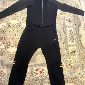 Hugo Boss tracksuit - Jätte fin mörkblå Hugo boss tränings dress med guld logga Zip up hoodien/koftan är i storlek S medans byxorna är i storlek XL, men tracksuiten sitter bra för någon med storlek S Skicket på den är mycket bra, endast nopprig Skicka meddelande vid några funderingar  Kolla gärna även in mina andra annonser