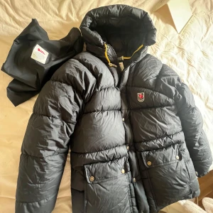 Fjällräven jacka - Hej! Säljer min fjällräven jacka som är i bra skick! Den är i den lite äldre modellen och man storlek,men inget märkvärdigt med tanke på att den är xxs (alla gula band är kvar) skriv om ni har fler frågor!Är 154 lång om ni undrar🥰