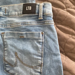 Ljusblå bootcut jeans från LTB - Säljer ett par ljusblå jeans från LTB, modell Fallon. Jeansen har snyggt utsvängda ben och normal passform. Tillverkade i mjukt denimtyg. Storlek: W27 L32. Jeansen är i bra skick, bara använda några få gånger.