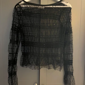 Svart transparent prickig blus - Supersnygg svart transparent blus med prickigt mönster och långa puffiga ärmar. Blusen har volangdetaljer☺️ALDRIG ANVÄND