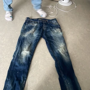 Jack & Jones Slim Glenn jeans blå - Säljer ett par Jack & Jones Slim Glenn jeans i blå tvätt med coola slitningar och blekta detaljer. Jeansen har klassisk femficksdesign, smal passform och är tillverkade i bomull. Perfekta för dig som gillar en streetig och avslappnad look.