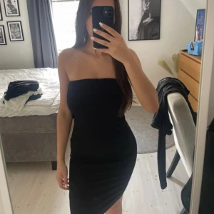 Bandeau klänning - NA-KD storlek xs. Svart bandeau klänning som har en silikon rand längst med hela överdelen för att hålla den plats. Knappt använd. 