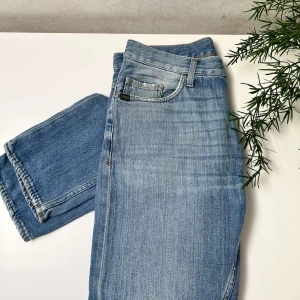 Ljusblå jeans från Tiger of Sweden (storlek 30/32) - Säljer ett par ljusblåa Tiger Of Sweden jeans med lite slitningar, storlek 30/32. Gott som nya! Hör av dig vid minsta lilla fundering.