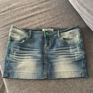 Lågmidjad jeanskjol - Lågmidjad as snygg jeanskjol, med gröna knappar och en urtvättad snygg stil.  i storlek 36💞skriv vid fler frågor💗