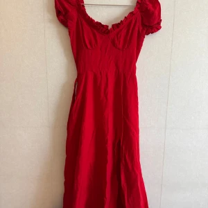 Röd klänning med puffärm och volang - Super fin röd klänning från Nakd. Kolla sista bild, en defekt på baksidan men som går att täcka med bältet som finns. Storlek 32 