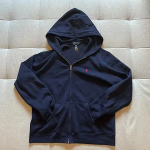 Marinblå hoodie från Polo Ralph Lauren - Säljer en marinblå hoodie från Polo Ralph Lauren med dragkedja och huva. Priset är ej hugget i sten! Tveka inte att skriva vid funderingar🤝