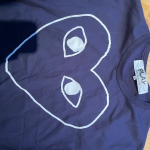 Mörkblå Cdg-T-shirt  - Säljer denna fräscha Cdg tröja som är i storlek M. Den har bara använts ett fåtal gånger. Hör av er vid minsta fundering!💫