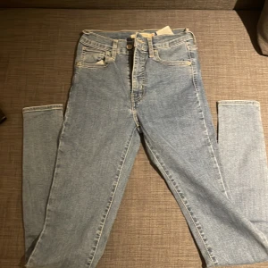 Levi's mile high jeans  - Säljer ett par ljusblå Levi's Mile High Super Skinny jeans med hög midja och klassisk femficksdesign. Jeansen har skinny fit och är tillverkade i stretchig denim för en tight och bekväm passform. Perfekta för dig som gillar en smal siluett och tidlös stil.