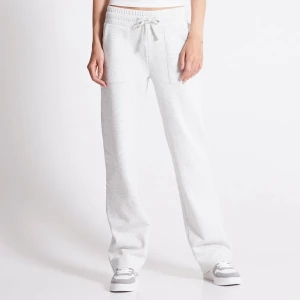 Grå mjukisbyxor med fickor  - Säljer ett par bekväma grå mjukisbyxor med elastisk midja och snörning. Byxorna har en avslappnad passform och är perfekta för en chill dag hemma. De har fickor på sidorna och en bakficka för extra funktionalitet.