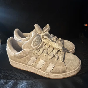Beige adidas Campus 00 - Skorna är använda i cirka en månad ser lite slitna ut på bild men är inte nå farligt alls när man tittar på dom. Storlek 44, skickas samma dag! Supersköna. Tvättar dom så gott det går innan jag skickar de!