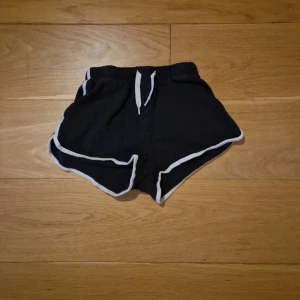 Sköna shorts - Svarta shorts med vit kant och snörning i midjan. Väl använda.